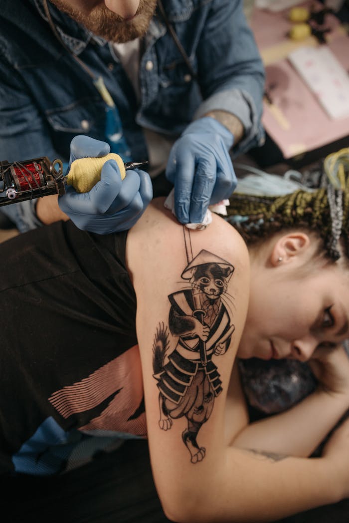 Close-up of tattoo artist working on a woman